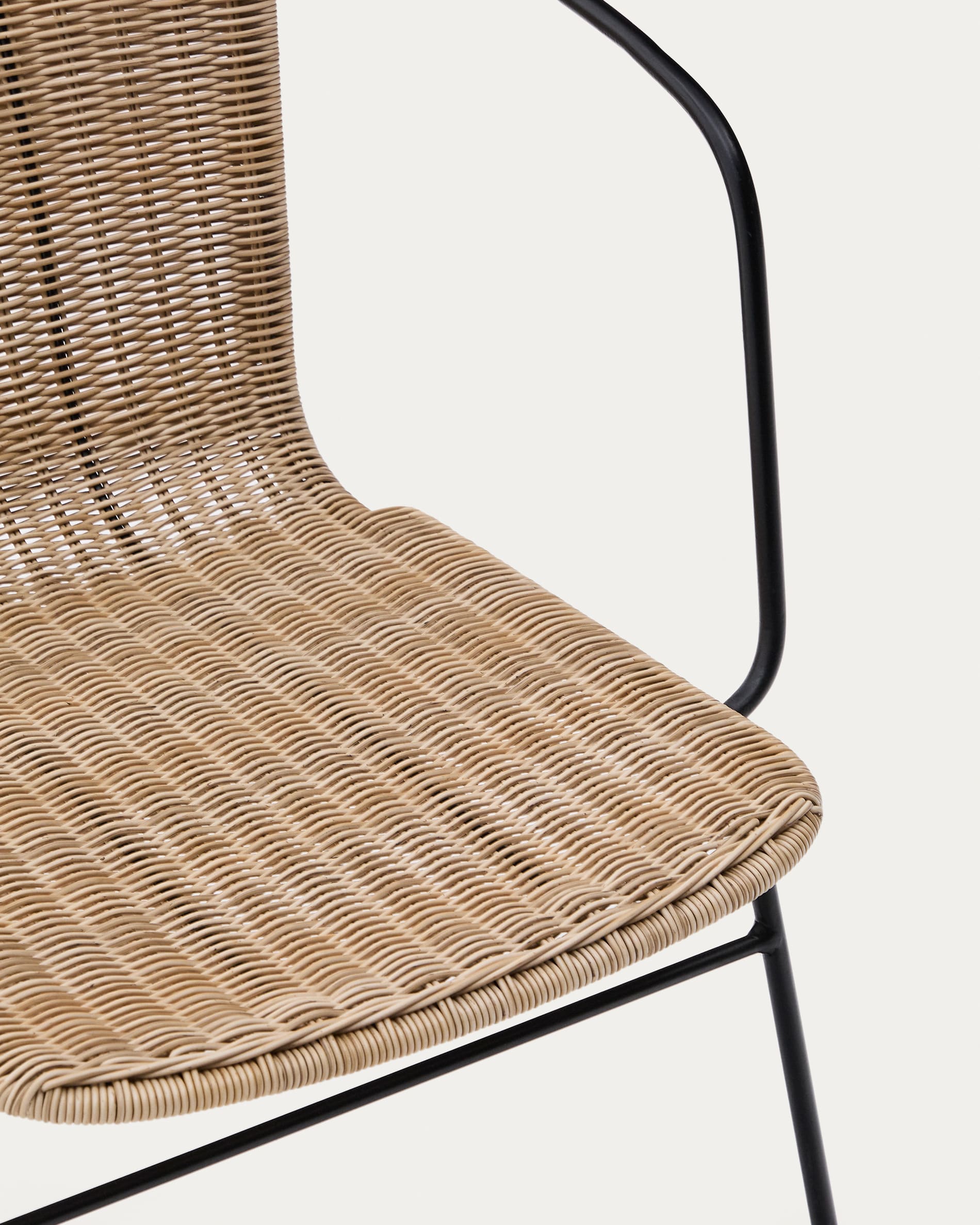Eltiera stackable chair in synthetic rattan with black steel frame and armrests