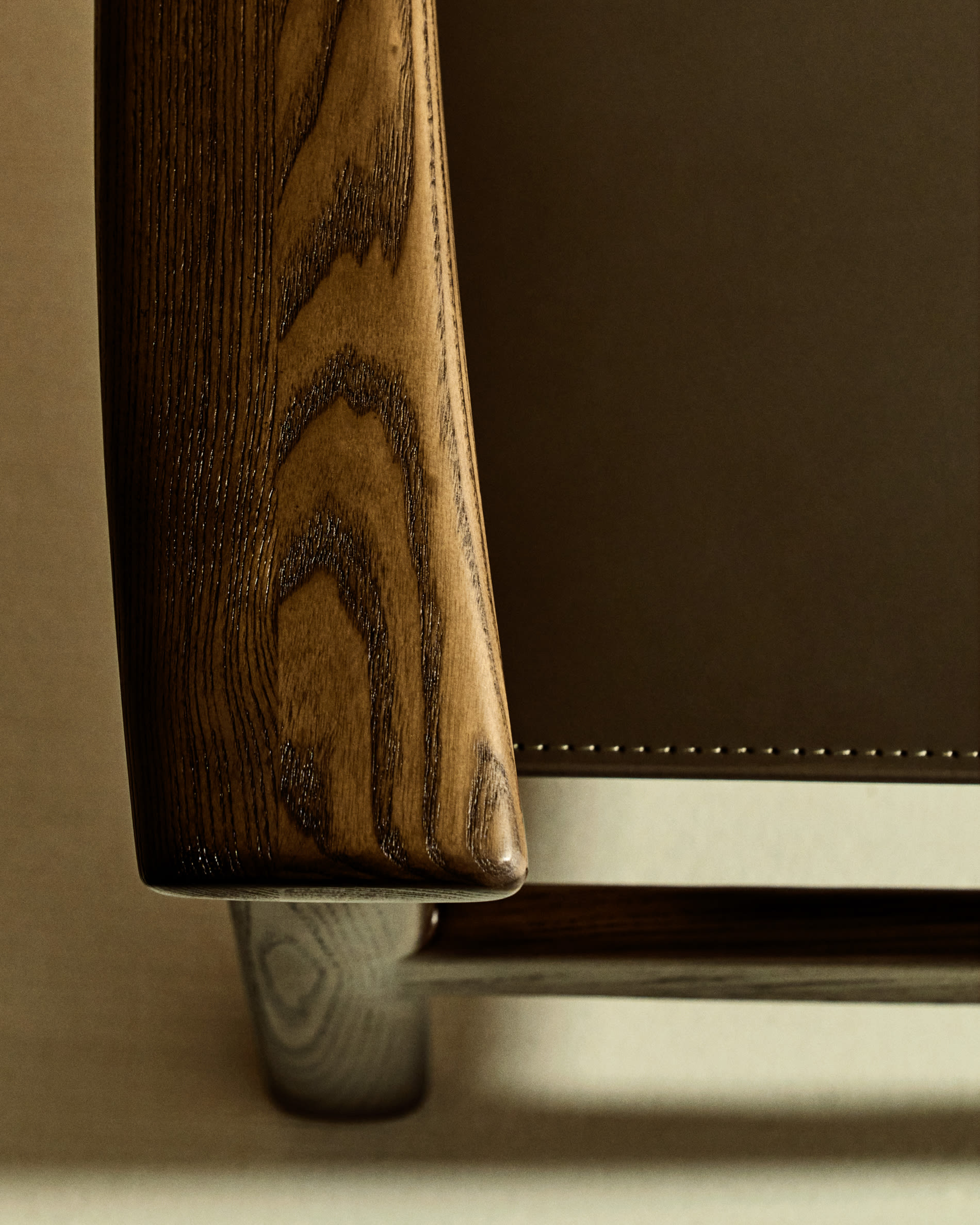 Jan chair made of dark brown recycled leather fibres and FSC 100% solid ash wood with walnut-coloured finish