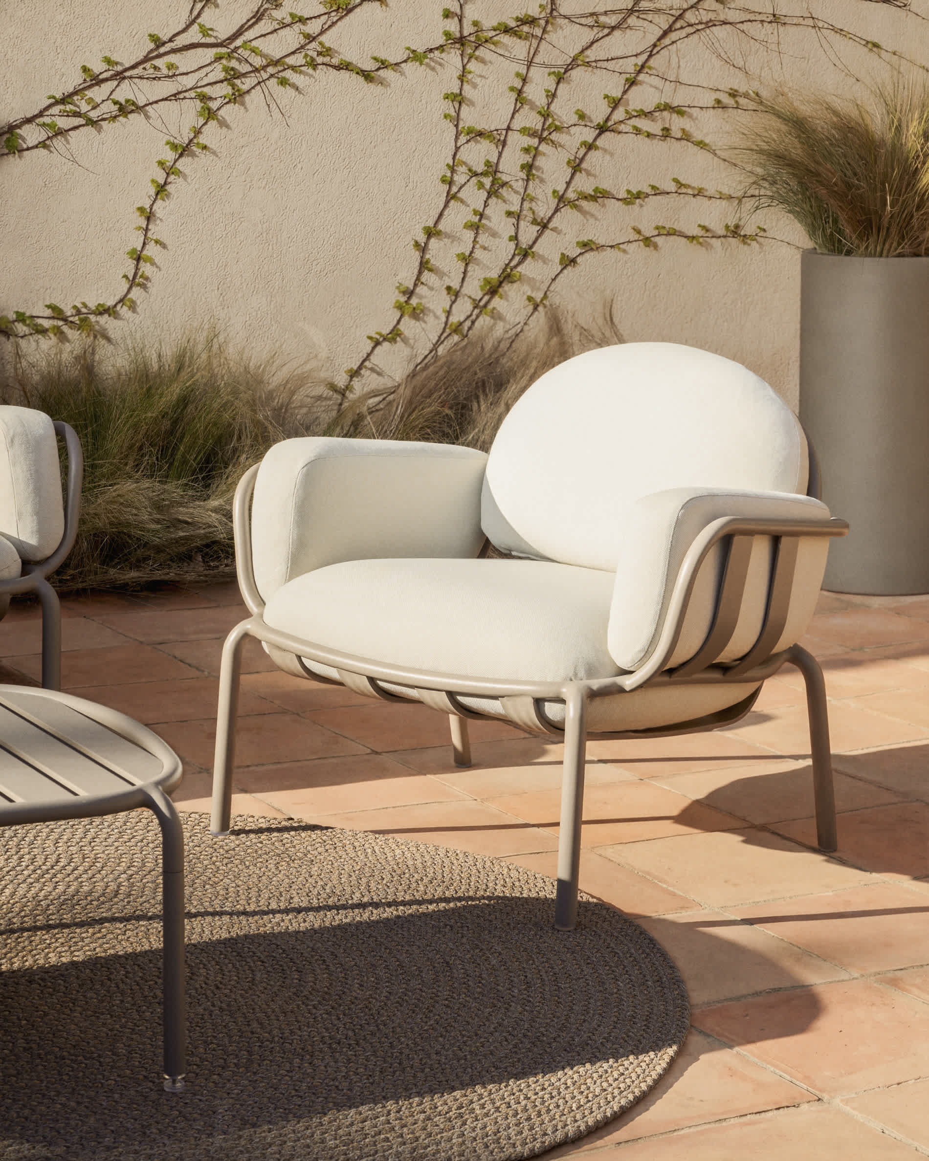 Joncols outdoor armchair in aluminium with taupe painted finish and beige cushions