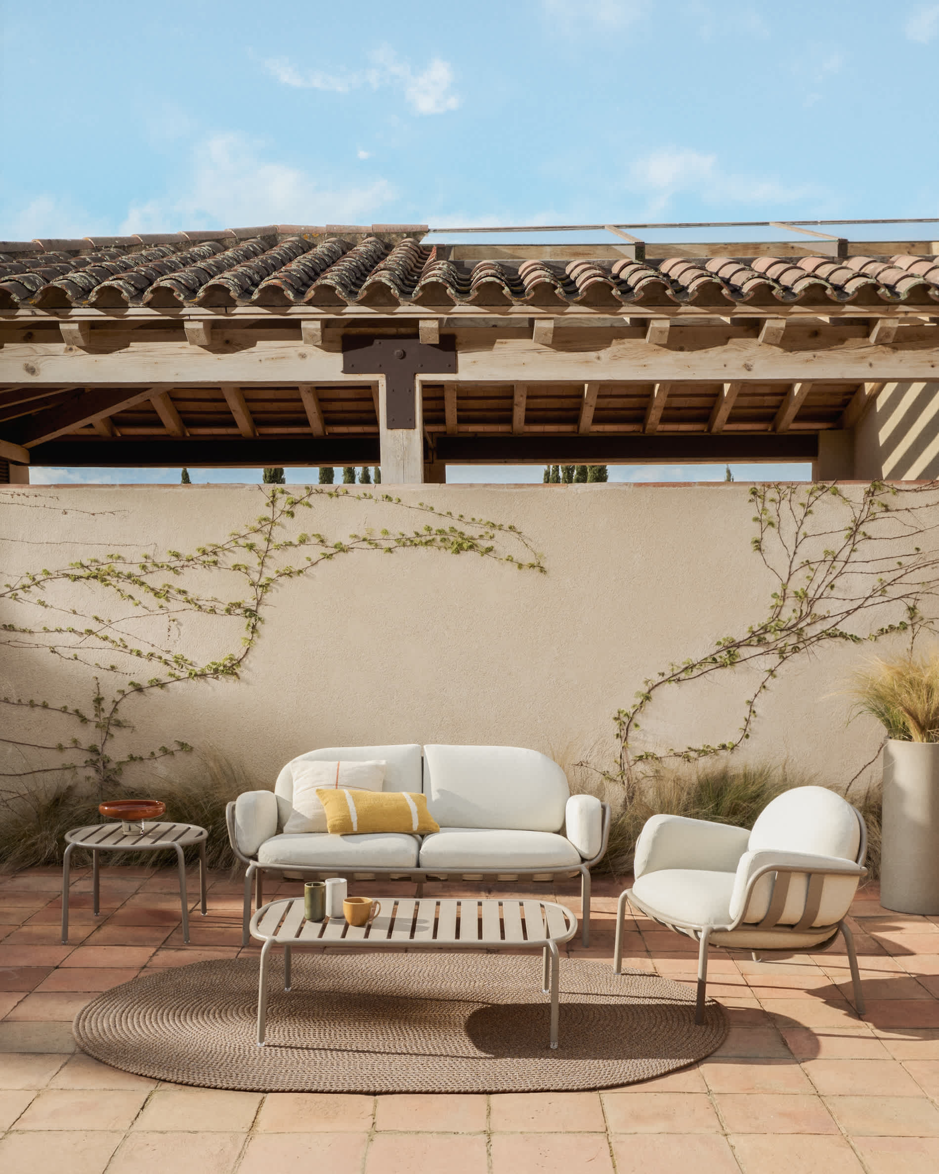 Joncols outdoor armchair in aluminium with taupe painted finish and beige cushions