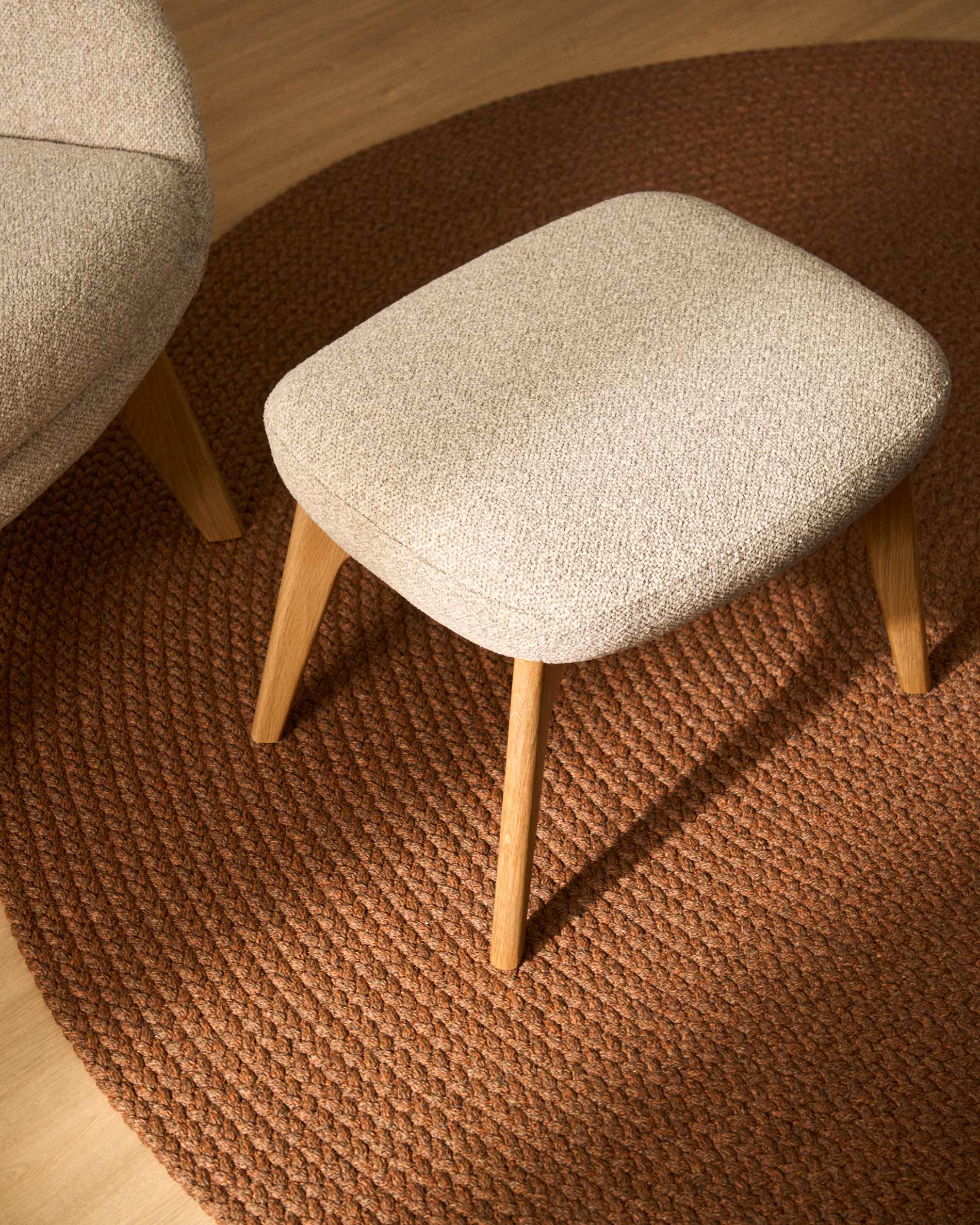 Adiran footrest in beige thick chenille with solid oak wood legs with a walnut finish