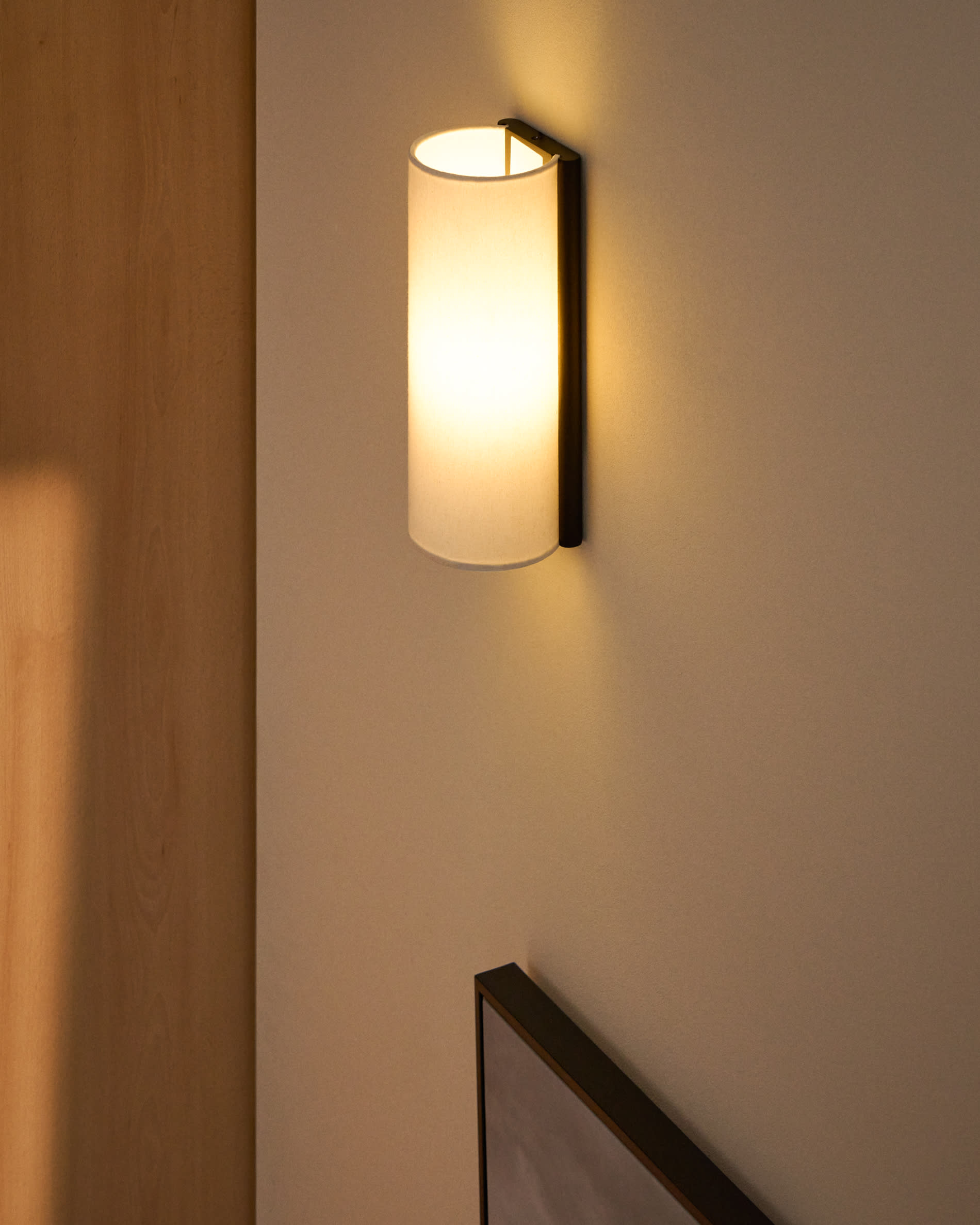 Umbran wall-mounted light fixture in dark brown rubberwood and beige linen