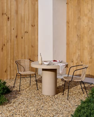 Eltiera stackable chair in synthetic rattan with black steel frame and arms