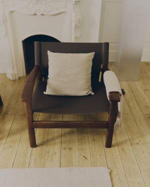 Fotel Jan wykonany z ciemnobrązowych włókien skóry z recyklingu i litego drewna jesionowego z wykończeniem w kolorze orzecha FSC 100%