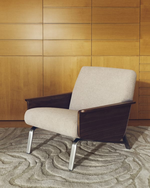 Amsen light brown armchair in walnut plywood with legs in brushed stainless steel