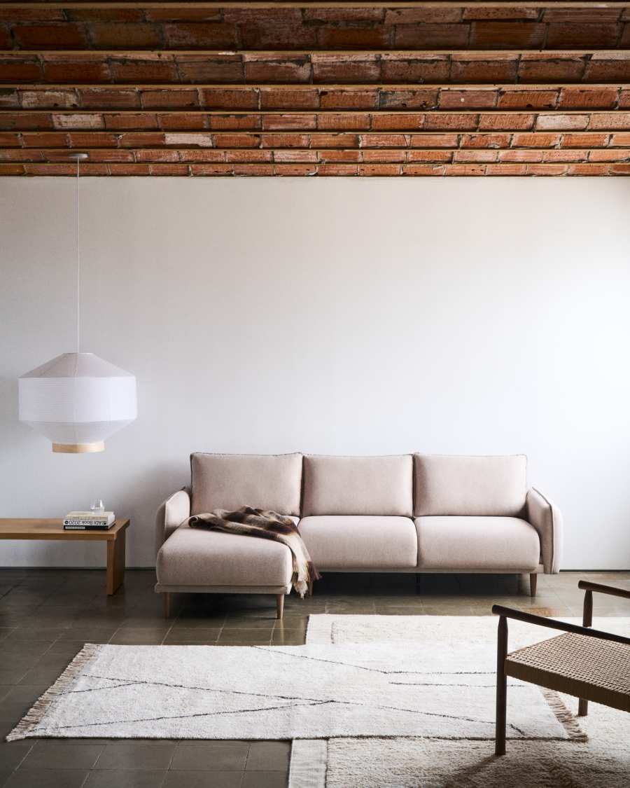 Canapé Carlota beige d'angle avec méridienne à gauche, sous un plafond en briques apparentes.