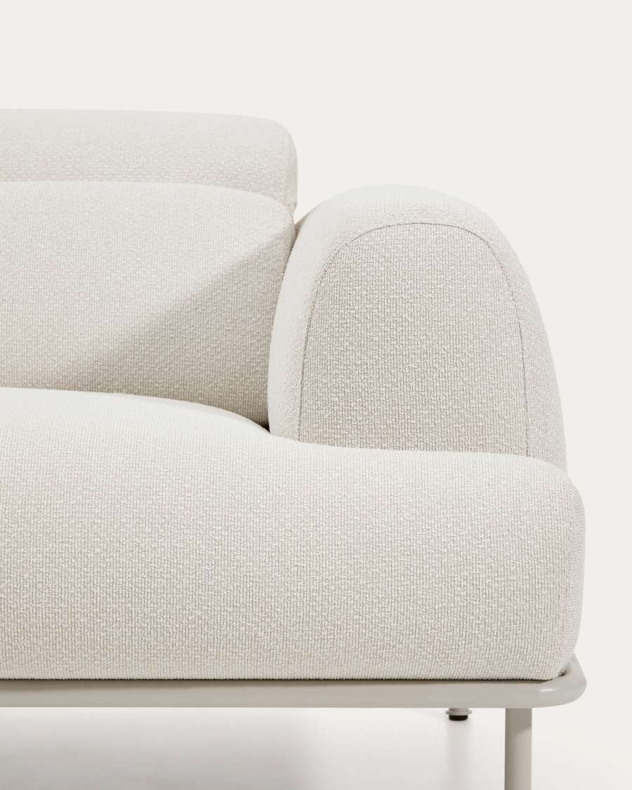 Gros plan de l'accoudoir arrondi et de l'assise du canapé Aurum en tissu bouclette écru.