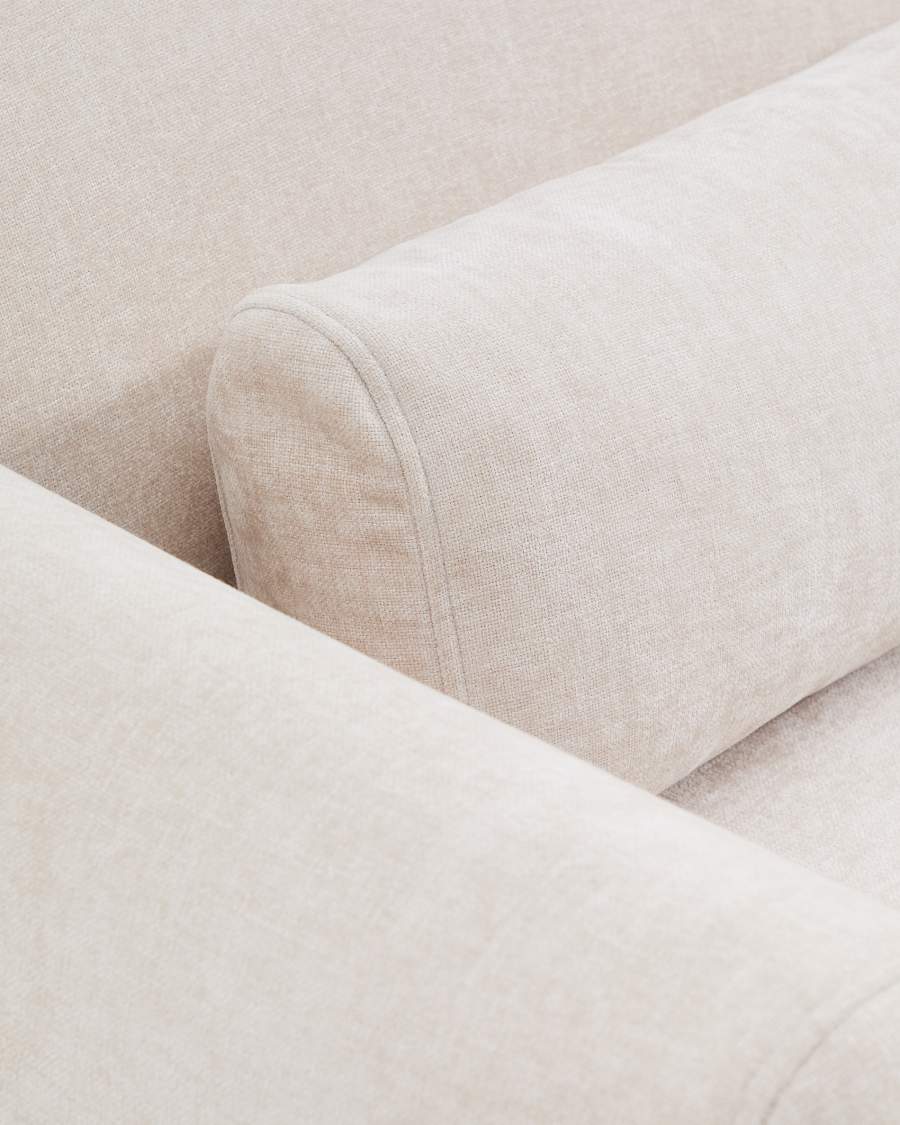 Gros plan d'un coussin cylindrique beige posé sur l'accoudoir du canapé Lares.