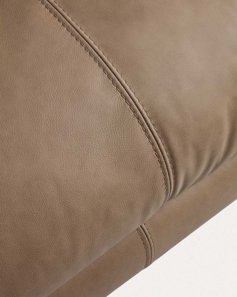Gros plan du cuir marron du canapé Veliro avec ses coutures piquées apparentes.