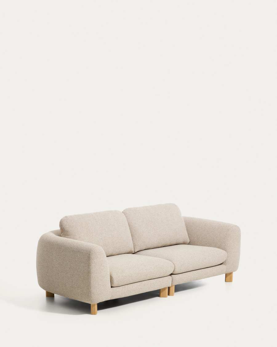 Canapé Vera 2 places beige vu de trois quarts, pieds en bois clair, fond beige uni.