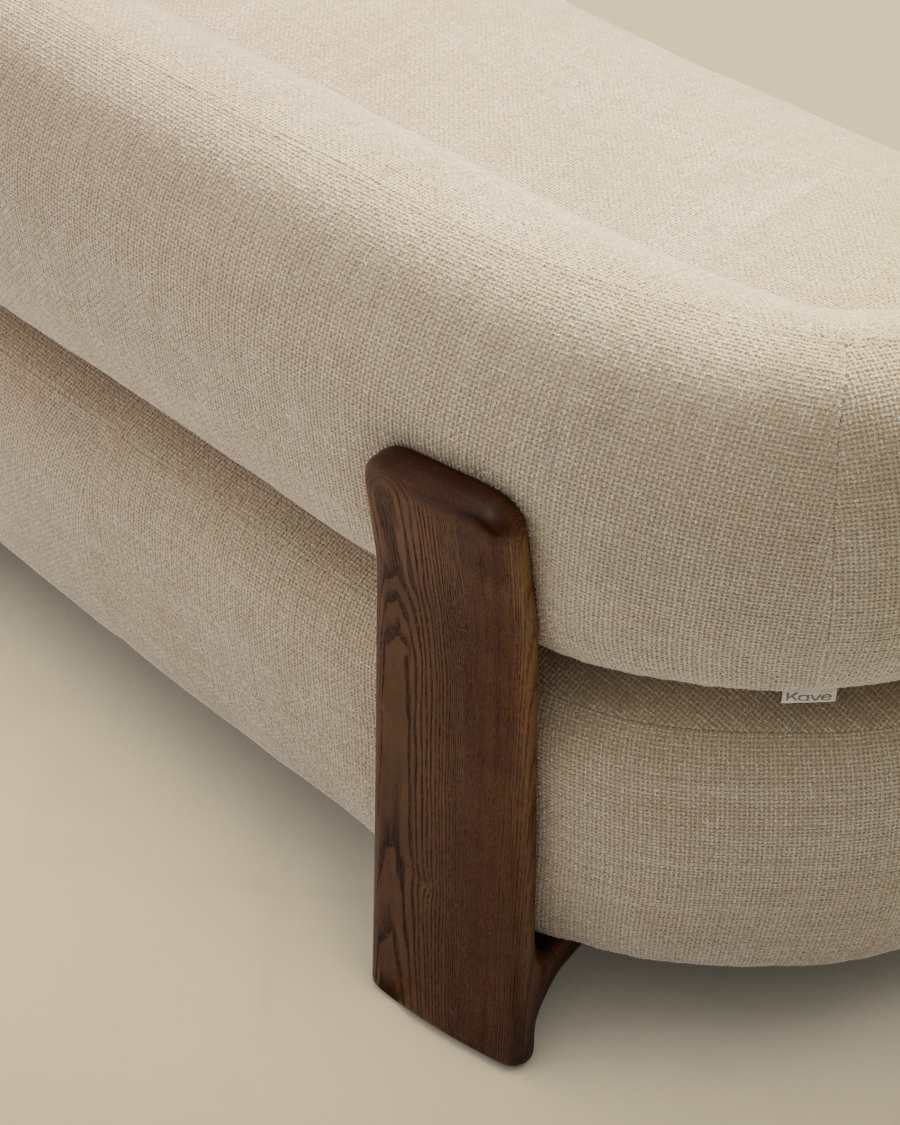 Gros plan du montant en bois foncé et de l'assise beige arrondie du canapé Granite.