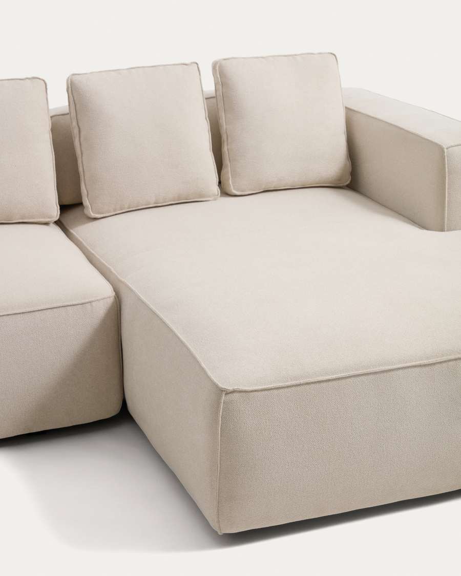 Gros plan de la méridienne et des coussins du canapé Marela en tissu écru bouclé.
