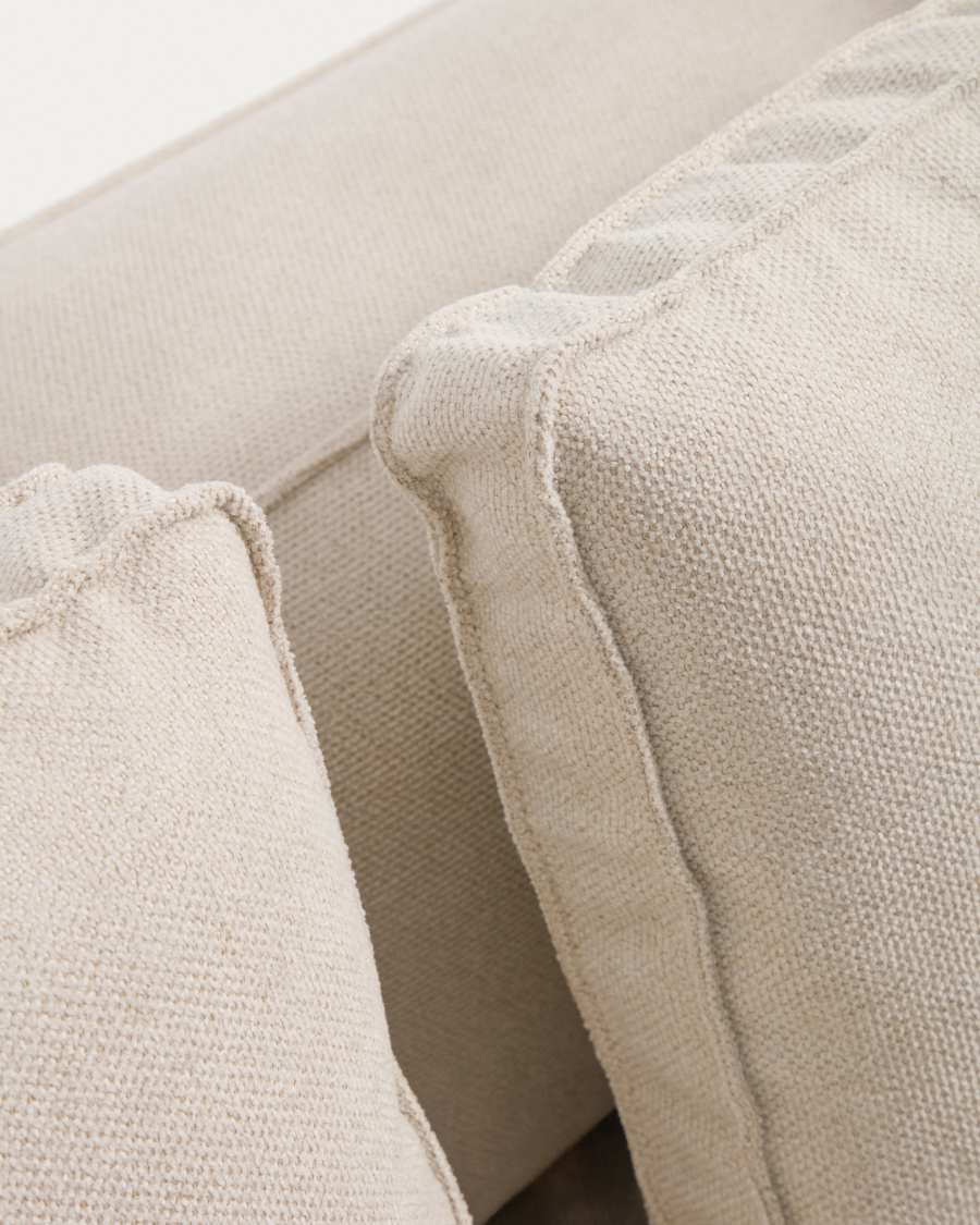 Gros plan de la chenille écrue et des coutures apparentes des coussins du canapé Marela.
